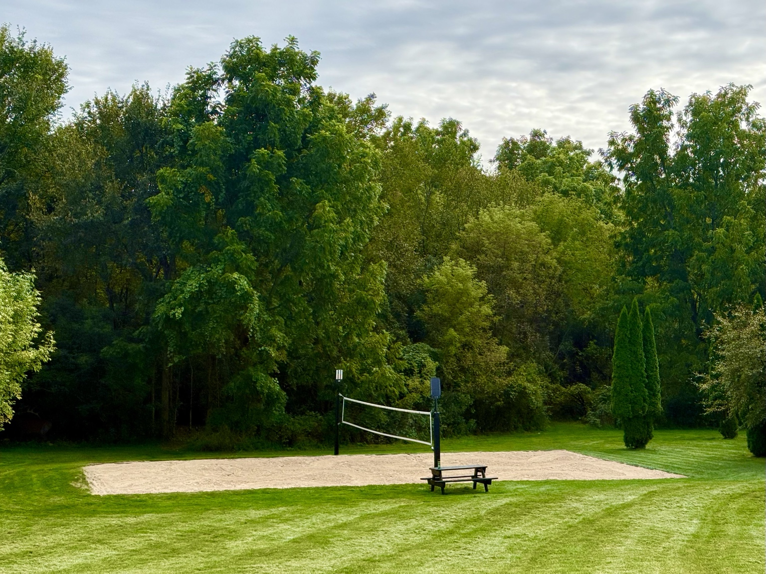 The Kumprey family’s backyard volleyball court surrounded by lawn and trees